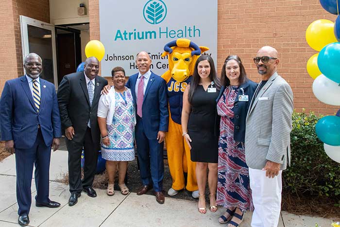 Group photo at the Atrium Health sign during the opening
