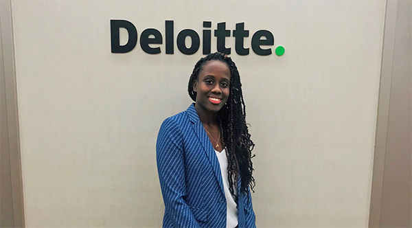 Photo of Ramoya Grandison by Deloitte sign