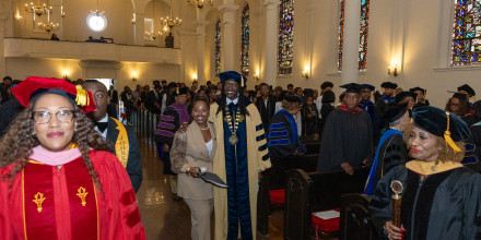 President Kinloch processes up the aisle with SGA President Islaea Anderson 