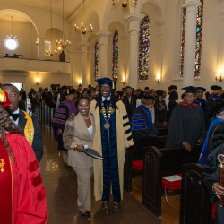 President Kinloch processes up the aisle with SGA President Islaea Anderson 