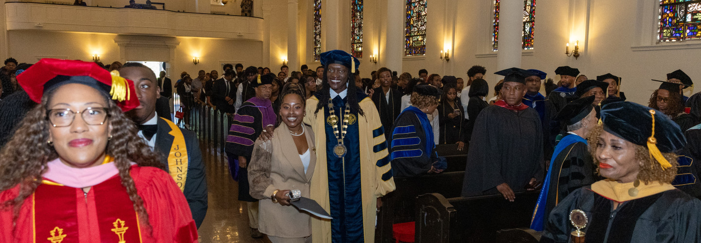 President Kinloch processes up the aisle with SGA President Islaea Anderson 