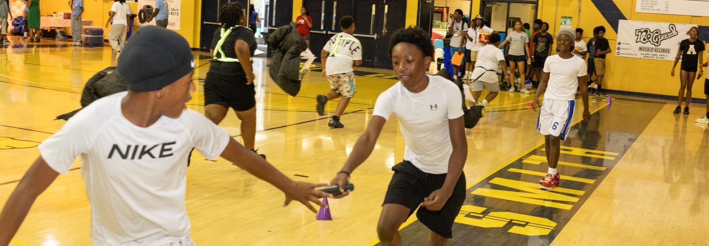 Kids at Impact Camp 2026 learning how track and field competitors  pass the baton 