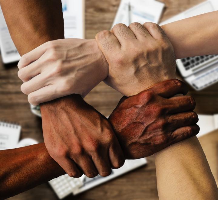 Generic photo of people of different races holding each other's wrists