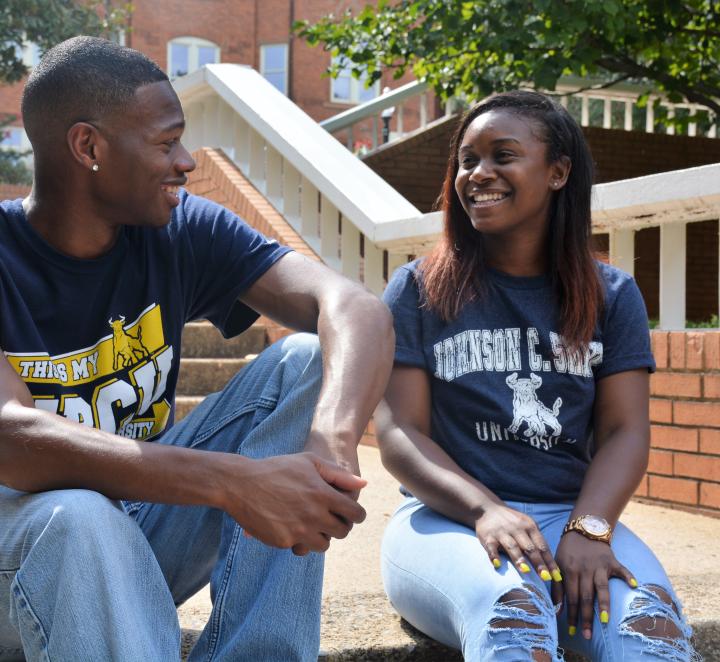 Two students sitting and talking on campus
