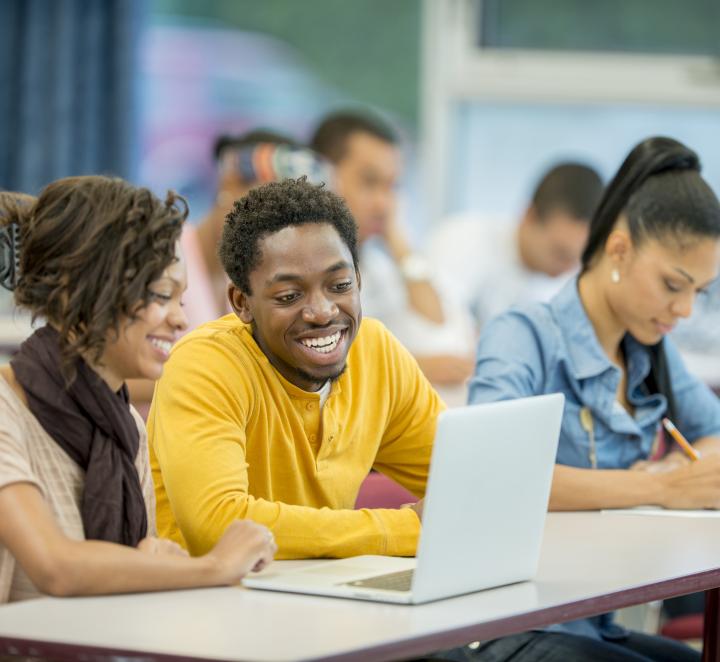 Group of students looking at laptop