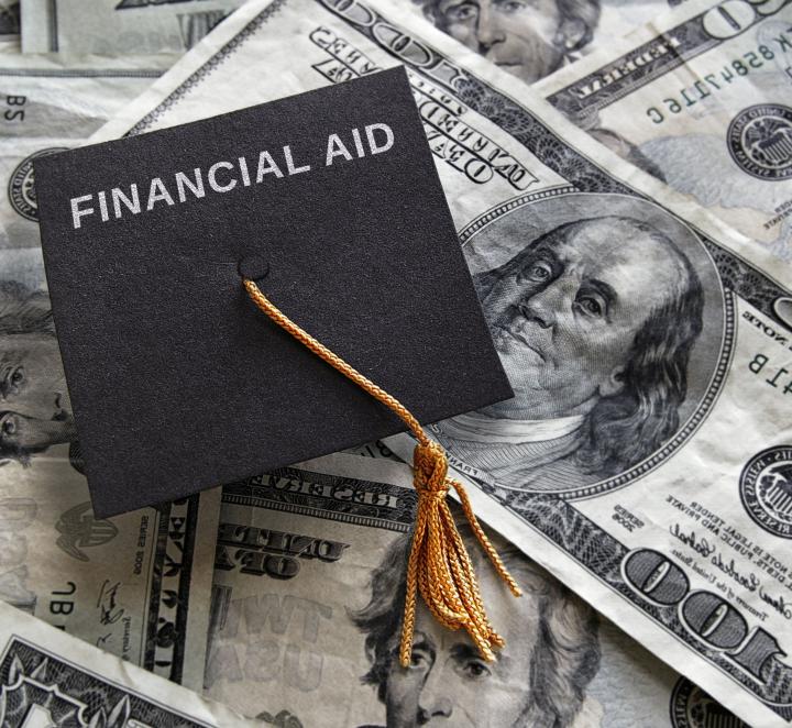 Photo of a mortarboard that says Financial Aid on top of $100 bills