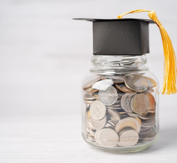 Bank full of coins with mortarboard on top