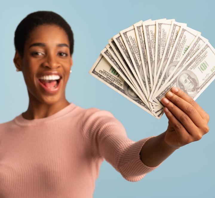 Woman holding out a fan of cash