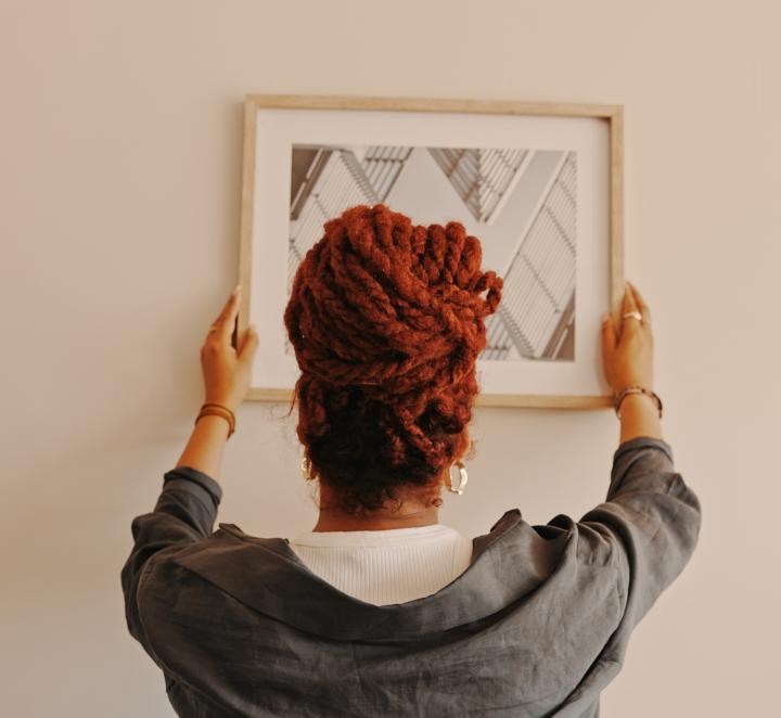 Woman putting a painting on the wall