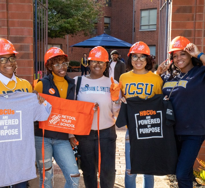 Students holding The Home Depot - Retool Your School Shirts
