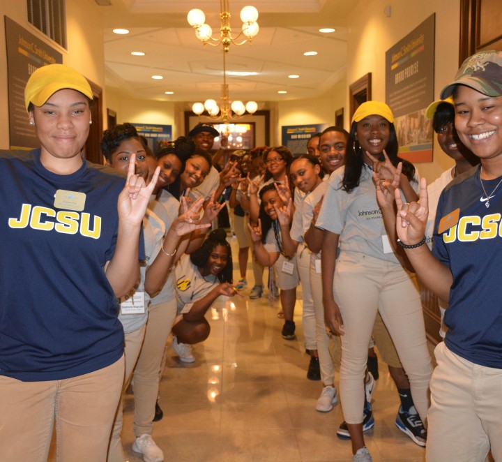 Group of students standing at the doors of Biddle welcoming visitors