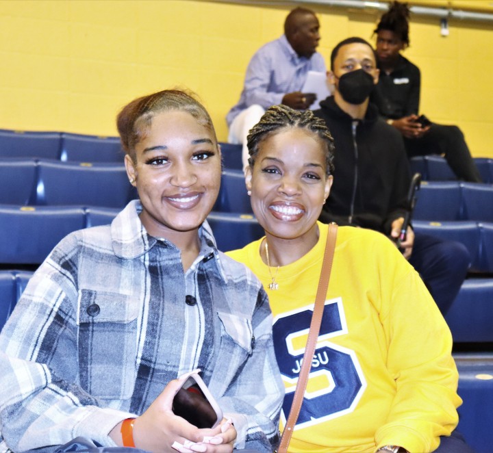 Two smiling students in the gym
