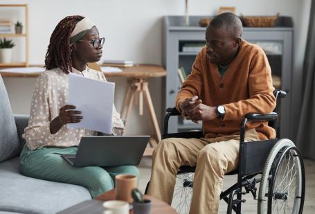 Woman sitting with a man in a wheelchair