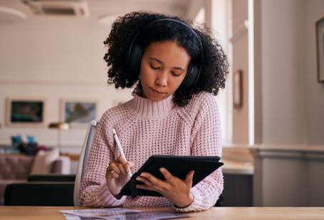 Woman with headphones on working on an iPad