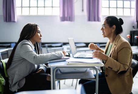 Student speaking to a teacher in a classroom