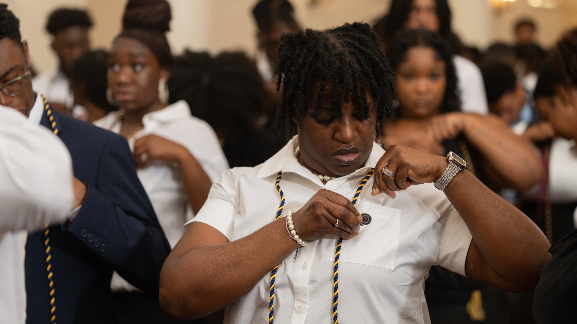 Freshmen place their pins on their shirts during Freshman Convocation 2023