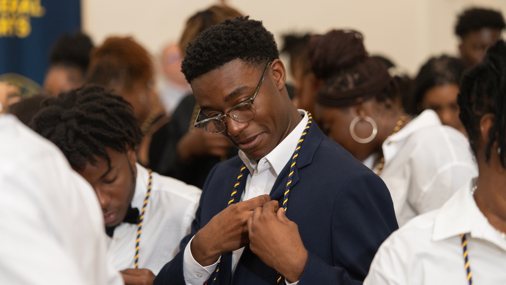 Freshmen place their pins on their shirts during Freshman Convocation 2023