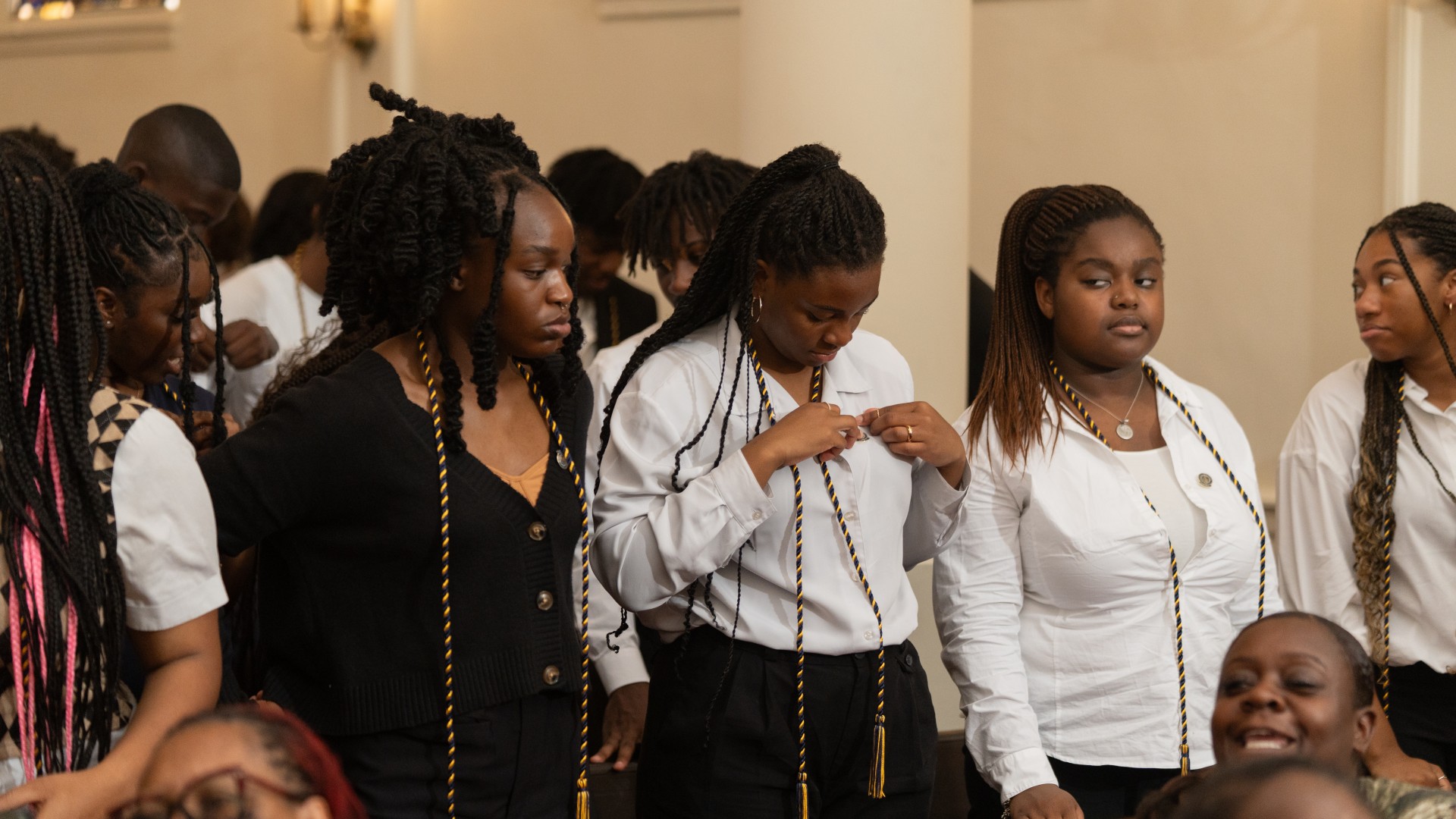 Freshmen place their pins on their shirts during Freshman Convocation 2023