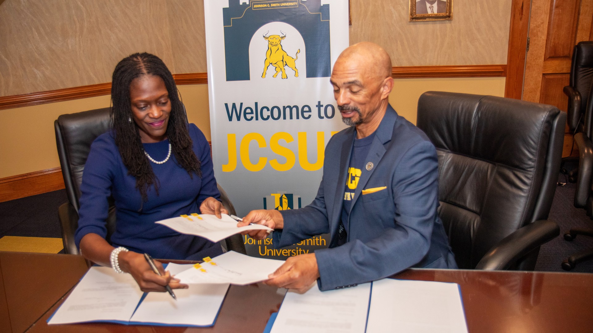 Dr. Valerie Kinloch and Trustee Steven L. Boyd trade contracts to sign