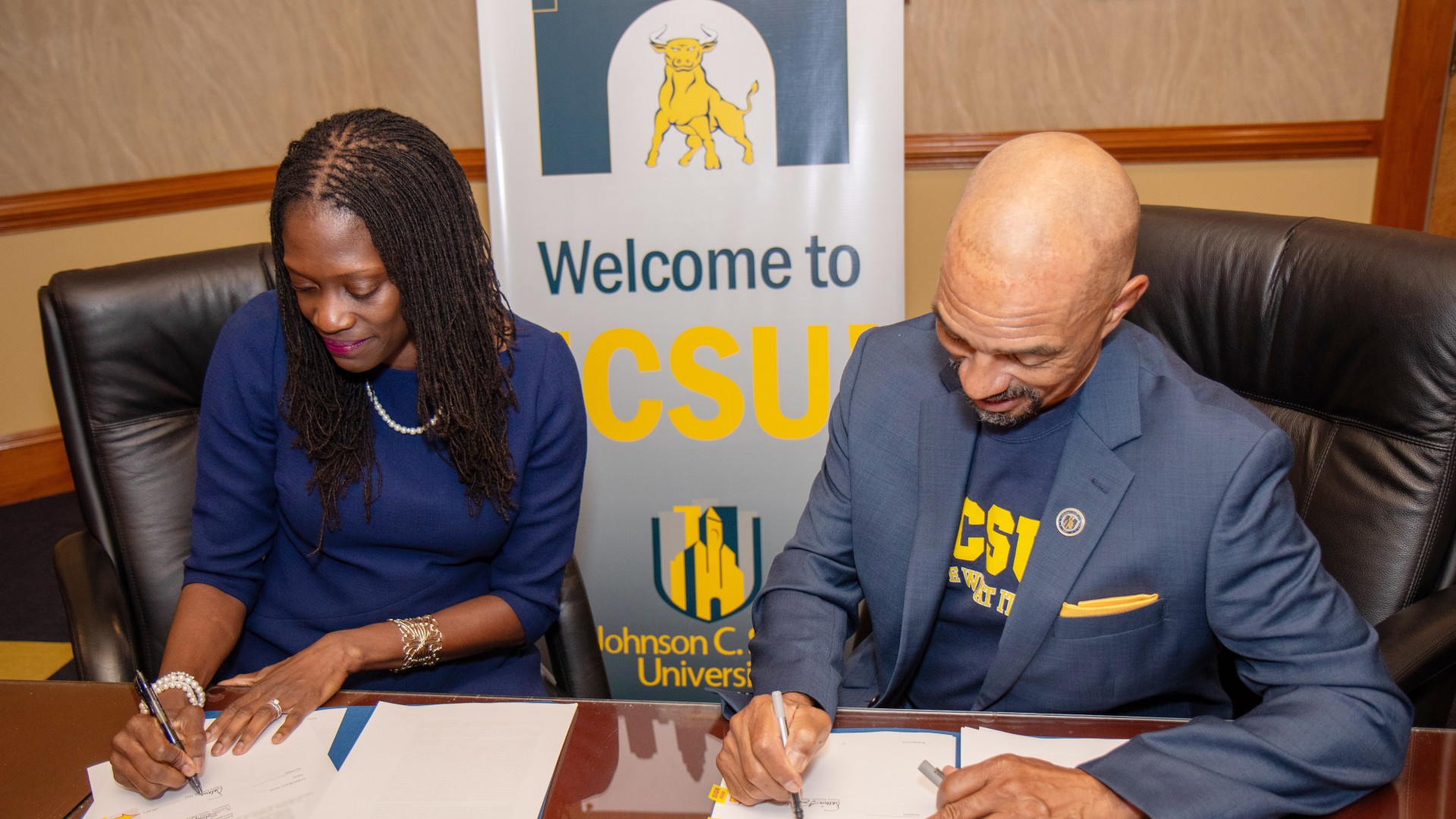Dr. Valerie Kinloch and Trustee Steven L. Boyd finish signing the contracts