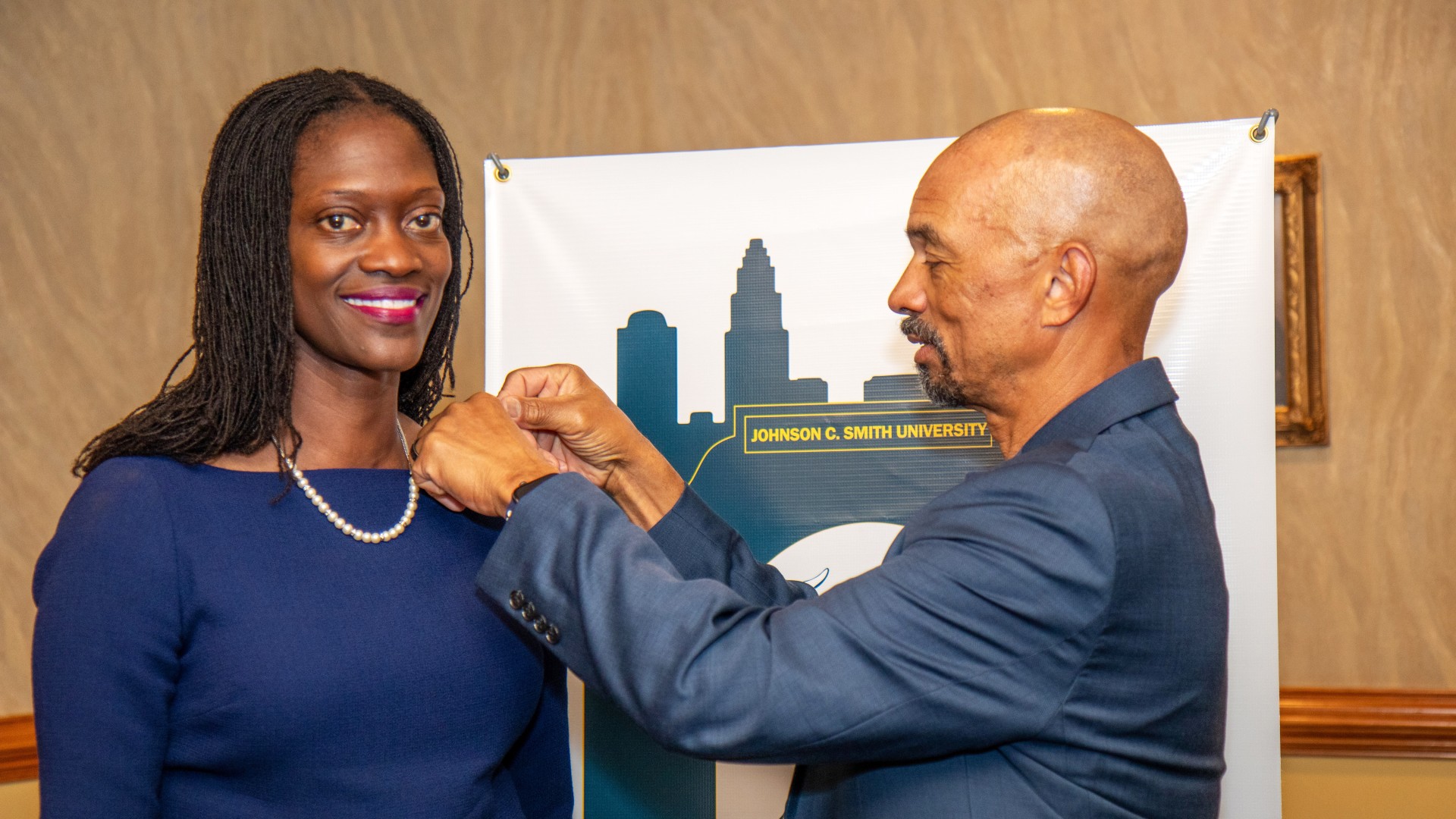 Trustee Steven L. Boyd places a JCSU pin on Dr. Valerie Kinloch