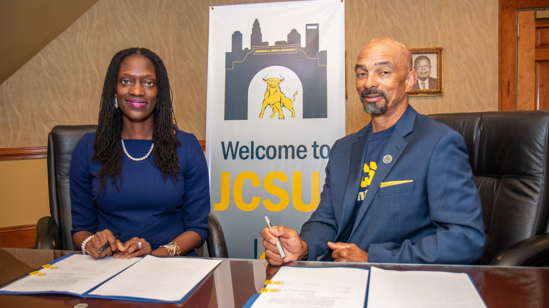 Dr. Valerie Kinloch and Trustee Steven L. Boyd prepare to sign the contracts