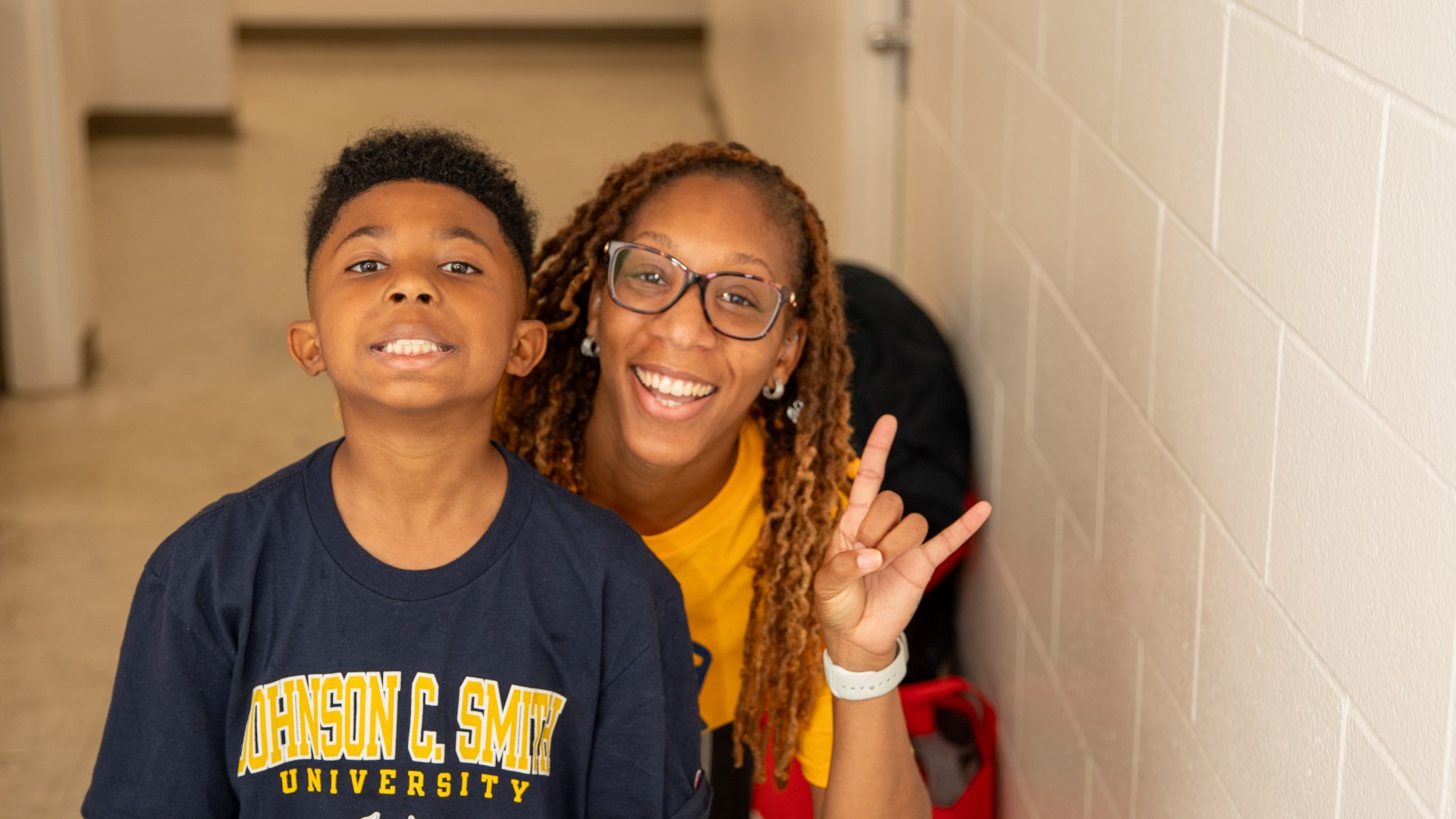 Child and woman posing in Myers Residence Hall during Freshman Move In 2023