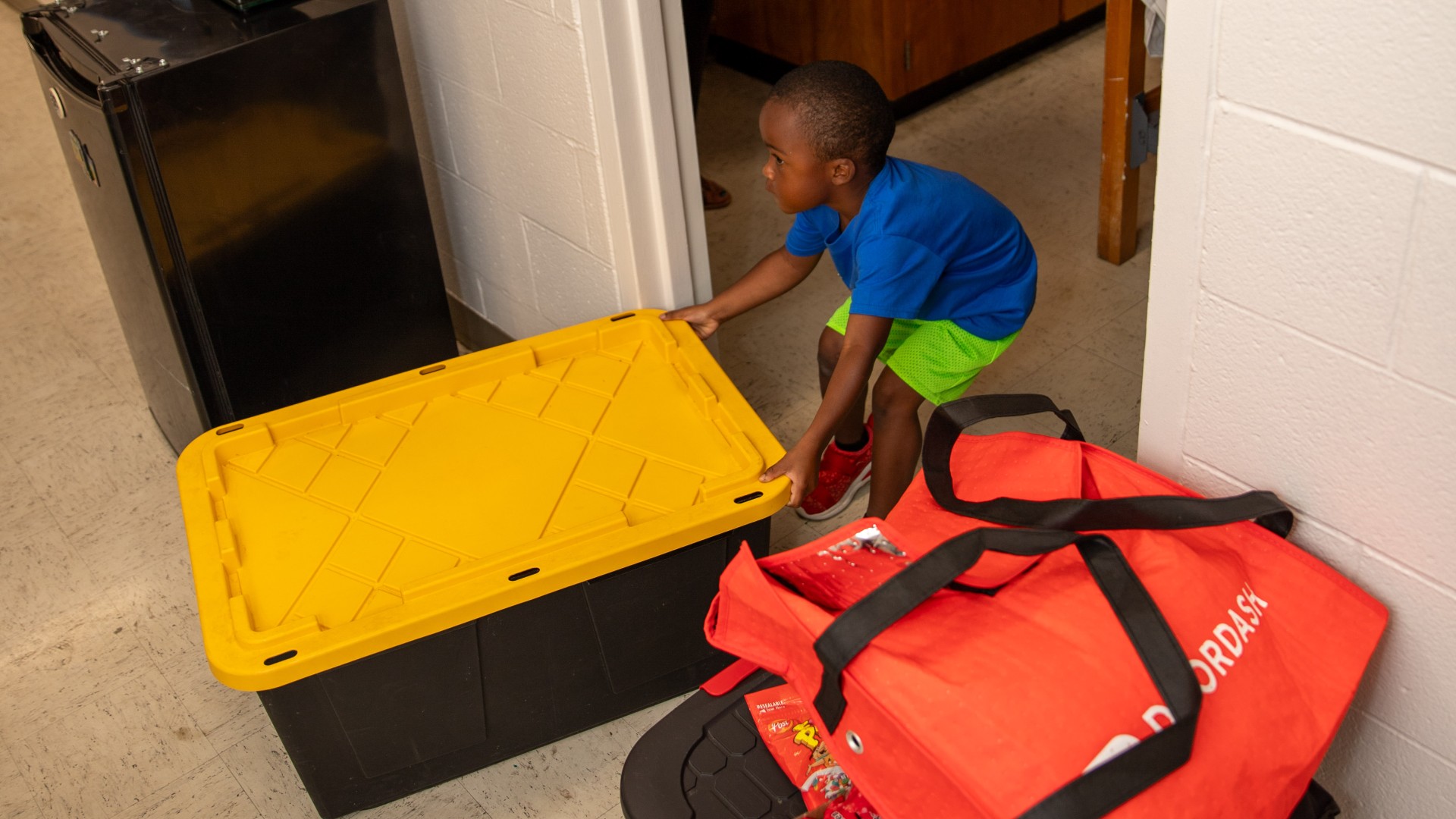 Child attempting to move a box into his brother's room during Freshman Move in 2023