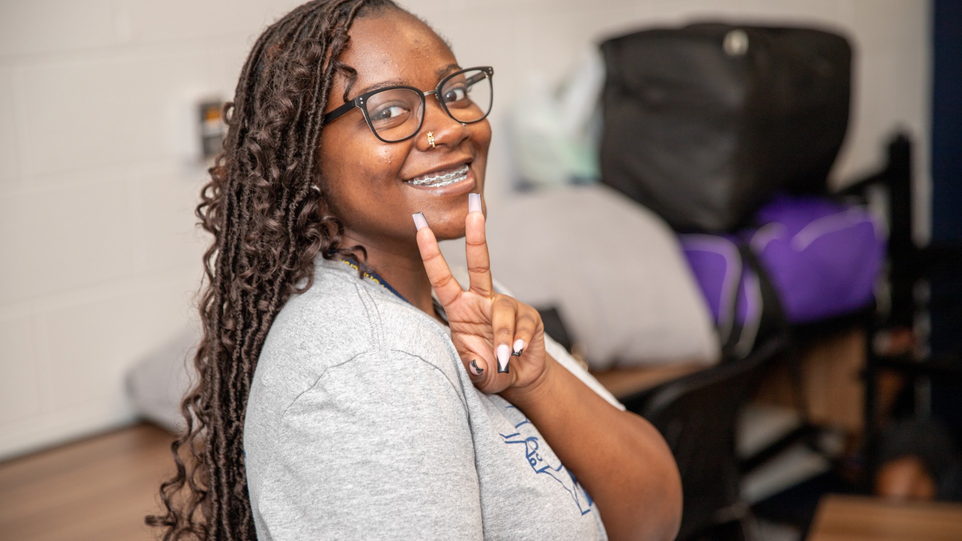 Student moved into her room smiling for the camera during Freshman move in 2023