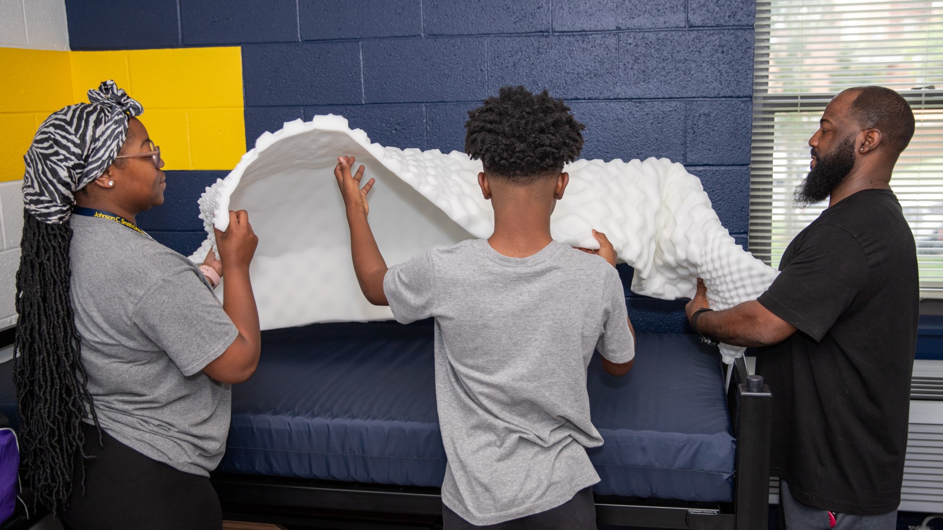 Family making a bed during Freshman Move in 2023