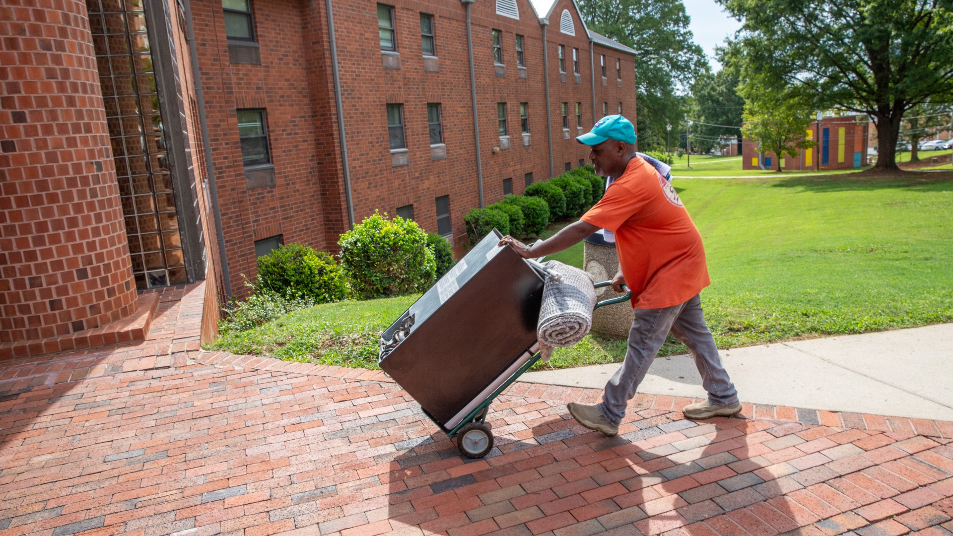 Man moving refrigerator into Greenfield Hall during Freshman Move in 2023