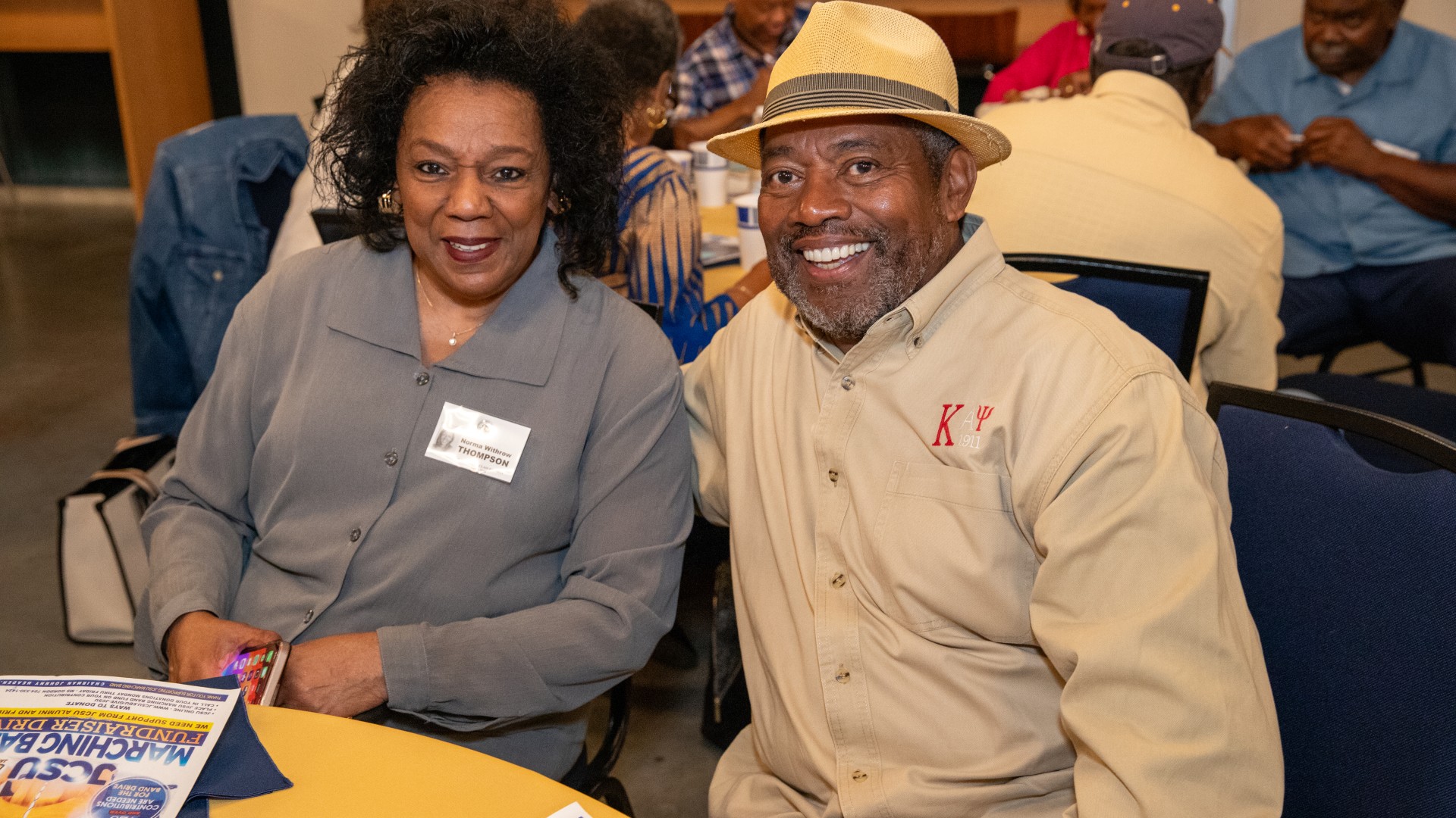 Alumni at the President's Breakfast smiling at the camera