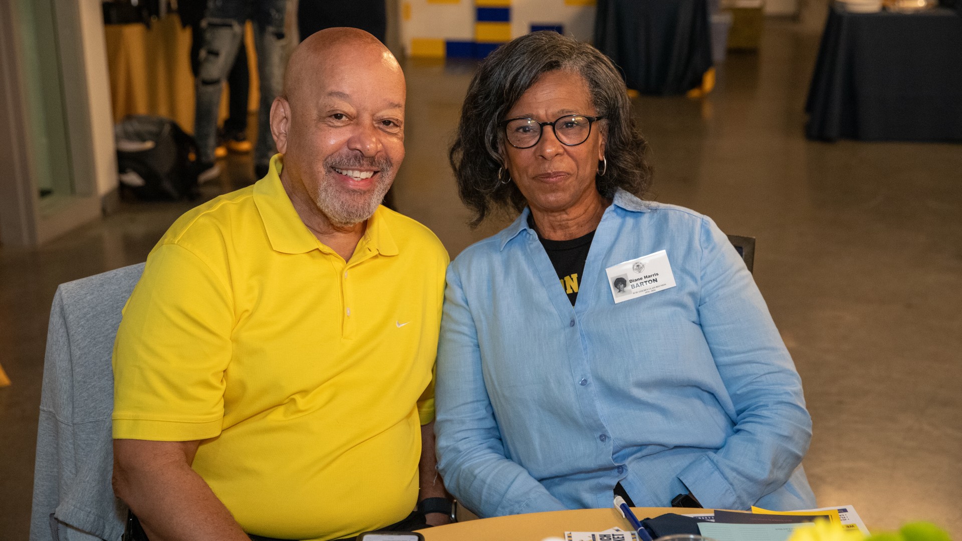 Alumni at the President's Breakfast smiling at the camera