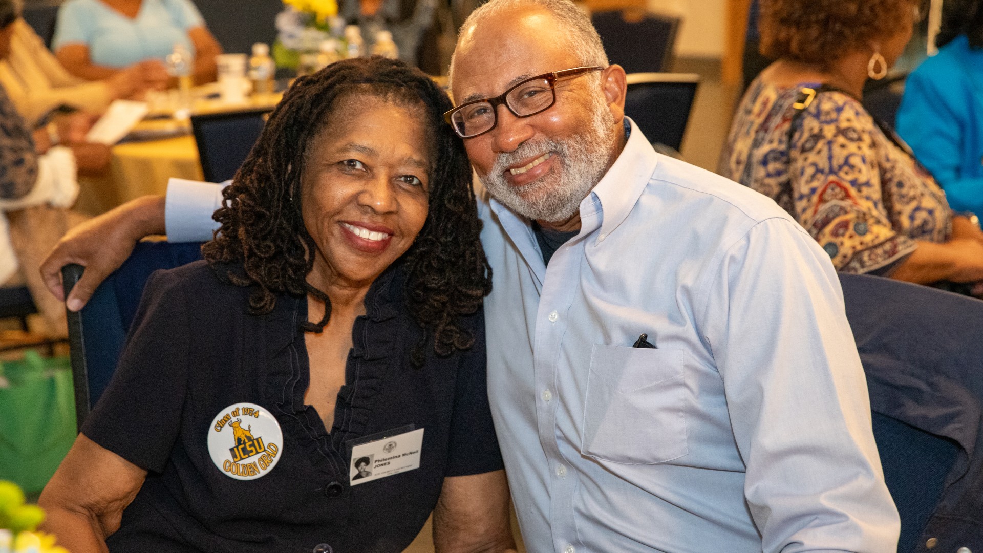 Alumni at the President's Breakfast smiling at the camera