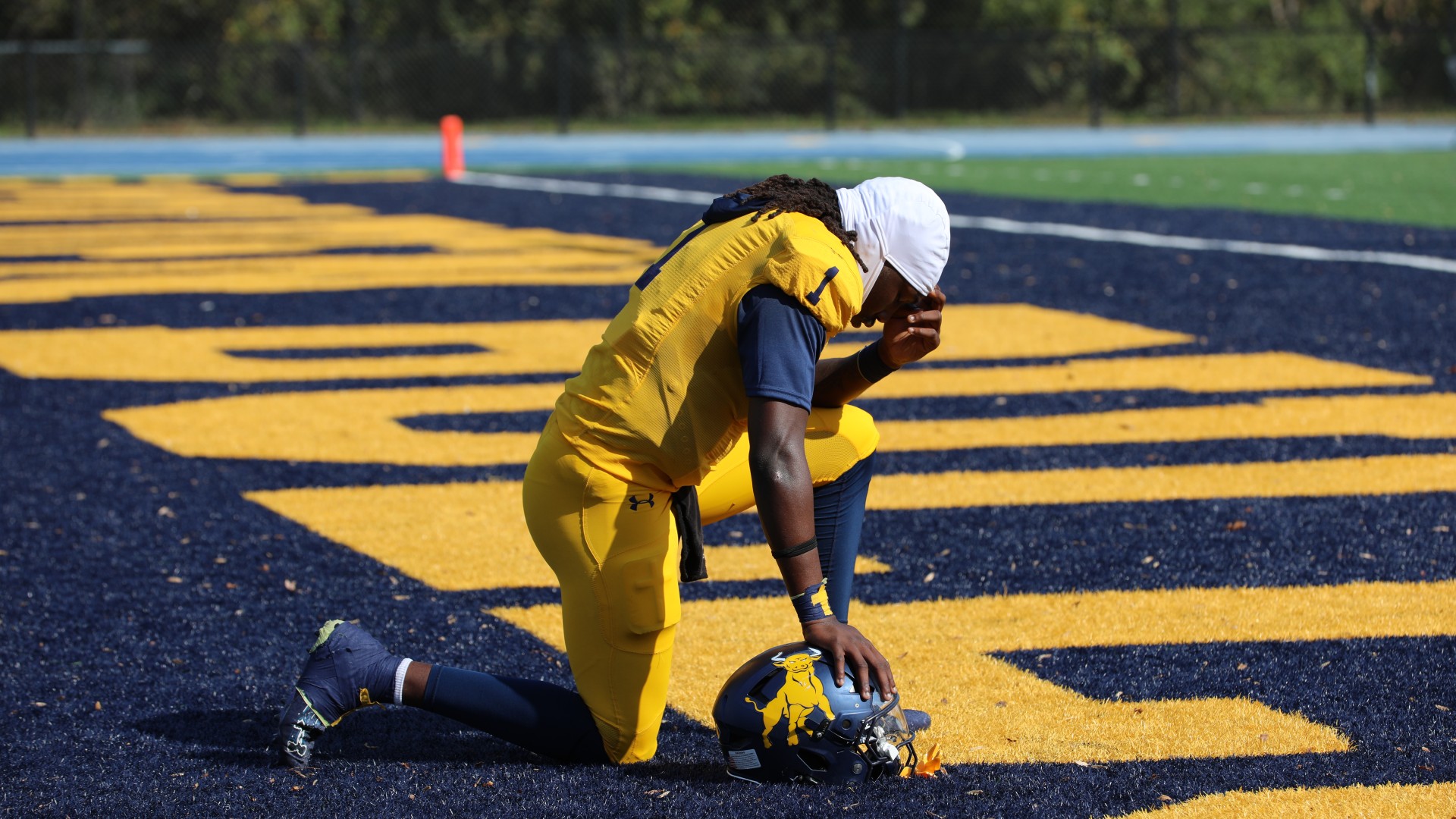 Student takes a prayerful moment before the game