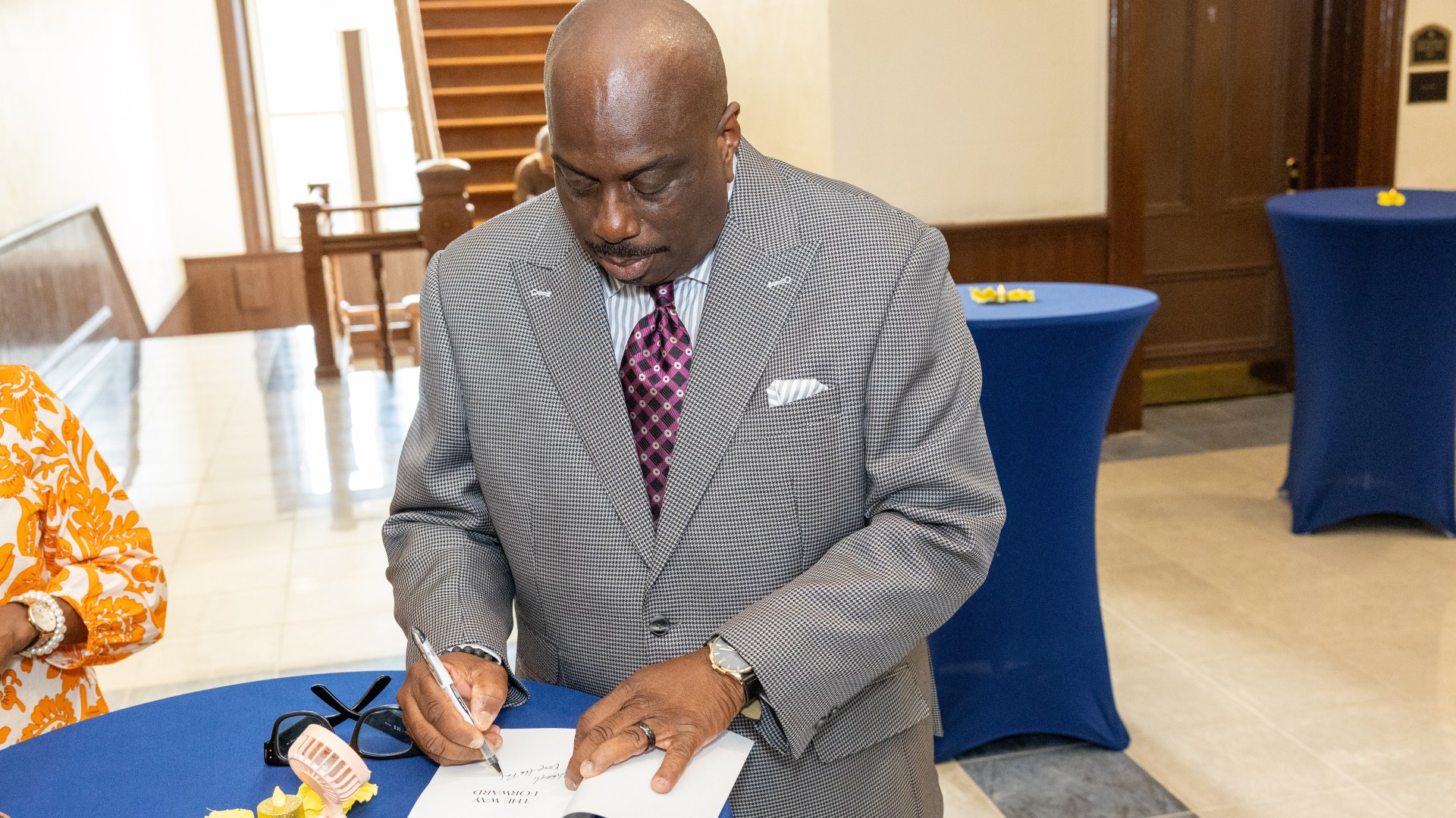 Malcolm Graham signs books at the reception before The Way Forward event